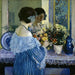 Girl in Blue Arranging Flowers - Frederick Carl Frieseke — displayed in an interior