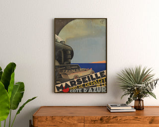 Manifesto Marsiglia vintage – Costa Azzurra – Roger Broders, incorniciato sopra una cassettiera in legno, tra delle piante.