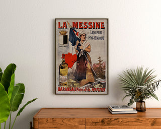 Manifesto pubblicitario vintage La Messine, liquore, incorniciato sopra una cassettiera in legno, tra piante.