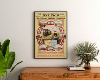 Vintage-Reiseplakat – Amsterdam, Marken und Volendam, gerahmt über einer Holzkommode zwischen Pflanzen.