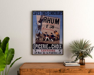 Vintage-Plakat Épicerie Lefèvre, Kaffee und Schokolade, gerahmt über einer Holzkommode zwischen Pflanzen.