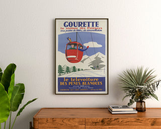 Vintage-Poster Gourette, Télévoiture, gerahmt über einer hölzernen Kommode, zwischen Pflanzen.