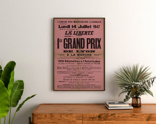 Vintage Grand Prix de Lyon walking race poster, framed above a wooden dresser, between plants.