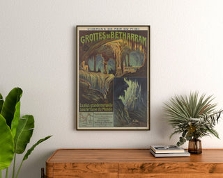Vintage Grottes de Bétharram poster, framed above a wooden dresser between plants.