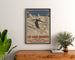 Vintage Les Eaux-Bonnes winter sports poster, framed above a wooden dresser, between plants.
