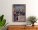 Manifesto vintage Lourdes, località balneari, incorniciato sopra una cassettiera in legno, tra piante.