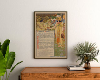 Poster vintage Marsiglia, feste del centenario, incorniciato sopra una cassettiera in legno, tra delle piante.