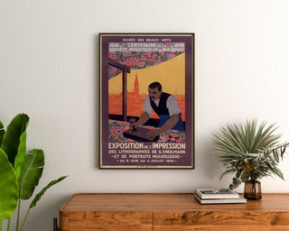 Vintage Mulhouse lithographic exhibition poster, framed above a wooden dresser, between plants.
