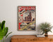 Manifesto vintage Paris, Saint-Denis, treni e tram, incorniciato sopra una cassettiera di legno, tra piante.