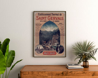 Vintage-Poster Saint-Gervais, Kurort, gerahmt über einer Holzkommode zwischen Zimmerpflanzen.