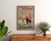 Vintage poster Two Little Vagabonds, framed above a wooden dresser, flanked by plants.